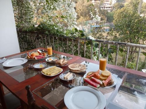 a table with plates of food on a balcony at Old Town Hotel in Kandy