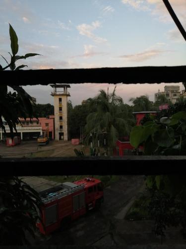 a view of a street with a red bus at Hotel Hoque Tower International in Chittagong