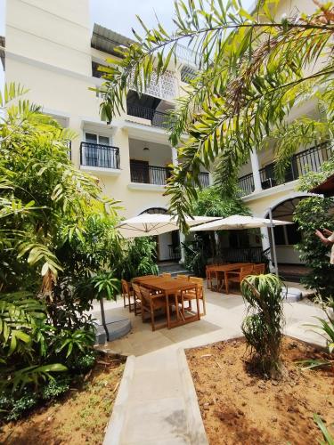 a courtyard of a building with tables and umbrellas at Mayilveedu Guest House in Tuticorin