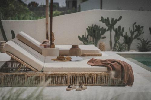 two beds on a table next to a pool at Dune Seseh in Munggu