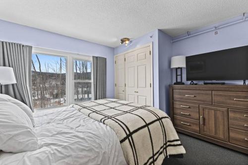 a bedroom with a large bed and a television at Stowe Ski Chalet - 3BR with In Unit Sauna in Stowe