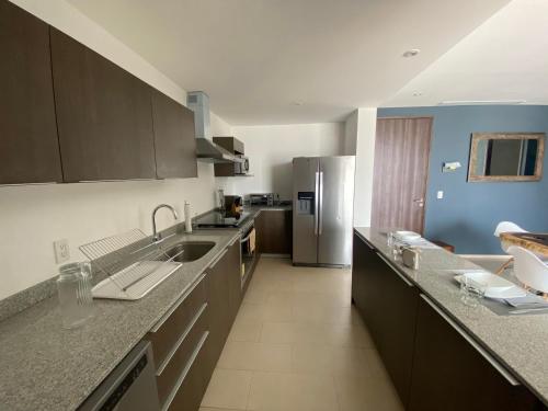 a kitchen with a sink and a refrigerator at Departamento 1 habitación - Latitud La Victoria a 5 minutos del centro in Querétaro