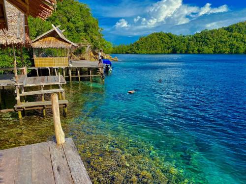 una mujer parada en un muelle en el agua en Avinsea Homestay, en Besir