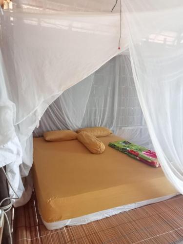 a bed in a tent with two pillows on it at Avinsea Homestay in Besir