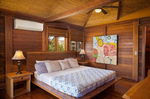 een slaapkamer met een bed in een kamer met houten wanden bij Casa Amico Beach House in El Gigante