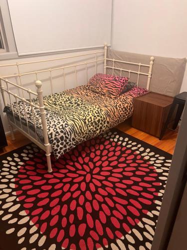 Schlafzimmer mit einem Bett mit einem roten und weißen Teppich in der Unterkunft Leafy garden in Sydney