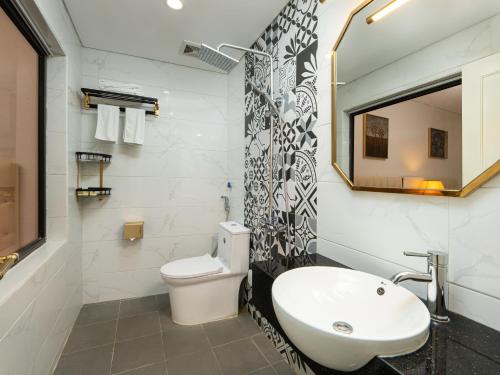a bathroom with a sink and a toilet and a mirror at Affa Boutique Hotel in Hanoi