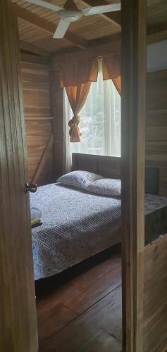 a bedroom with a bed and a window at Cabaña Palo Verde in Puntarenas