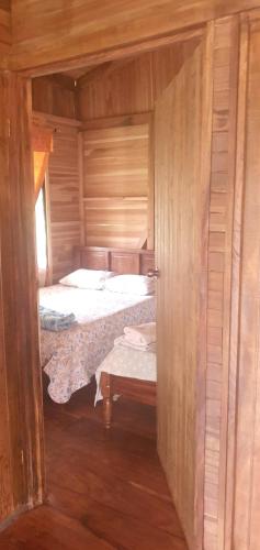 una camera con due letti in una cabina di legno di Cabaña Palo Verde a Puntarenas