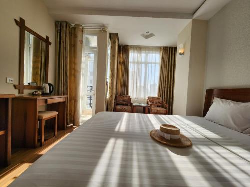 una habitación de hotel con una cama con sombrero en Golden Sea Hotel, en Nha Trang