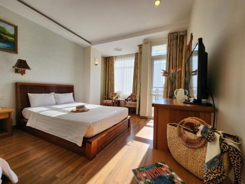 a hotel room with a bed and a television at Golden Sea Hotel in Nha Trang