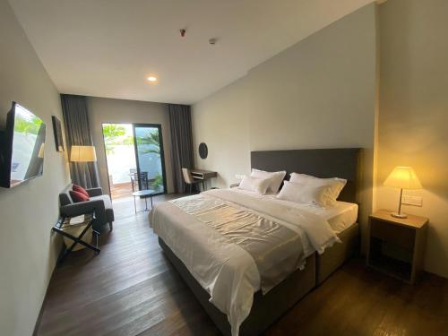 ein Schlafzimmer mit einem großen Bett und einem Balkon in der Unterkunft ONYX HOTEL & VILLA in Tanjunguban