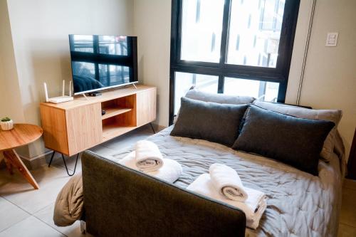 a bedroom with a bed with towels on it at 4) Hermoso departamento cómodo y equipado! in Godoy Cruz