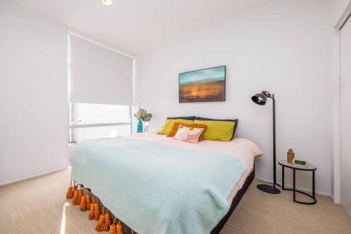 a bedroom with a large bed with yellow pillows at Freemans Bay Botanical Loft - Walk to Ponsonby & Waterfront in Auckland