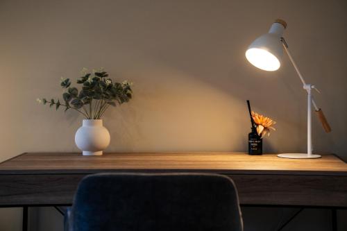 a desk with a lamp and a vase of flowers at Yarra Valley Serenity House in Golf Course Resort in Wonga Park