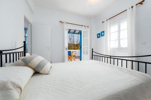 a white bedroom with a large bed in a room at ALYKI'S FAMILY POOL Villa in Aliki