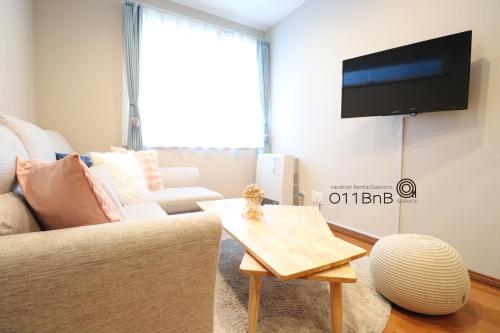 a living room with a couch and a tv at YI HOUSE MAX 8people 2BR 1 minute walk from tram station in Sapporo
