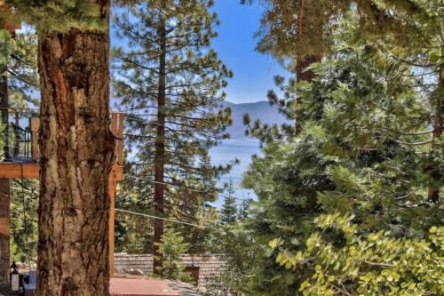 a view of a lake from between trees at Cozy Designer Decorated Cabin Near Slopes Fireplace Peekaboo Lakeview in Carnelian Bay
