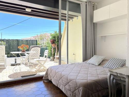 - une chambre avec un lit et une terrasse avec une table dans l'établissement Studio 4 Couchages avec Jardin et Piscine à Bormes-les-Mimosas - FR-1-251-825, à Bormes-les-Mimosas