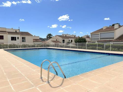 une piscine avec une rampe en métal à côté de certaines maisons dans l'établissement Studio 4 Couchages avec Jardin et Piscine à Bormes-les-Mimosas - FR-1-251-825, à Bormes-les-Mimosas