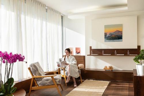 a woman sitting in a chair in a room with a laptop at InterContinental Genève by IHG in Geneva