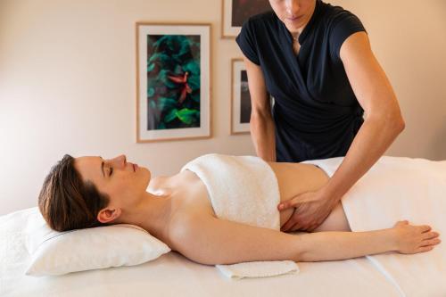 a woman getting a back massage from a therapist at InterContinental Genève by IHG in Geneva