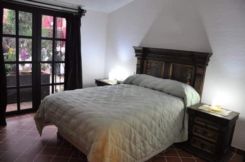 - une chambre avec un grand lit et 2 tables de chevet dans l'établissement Hotel boutique sana, à Cuernavaca