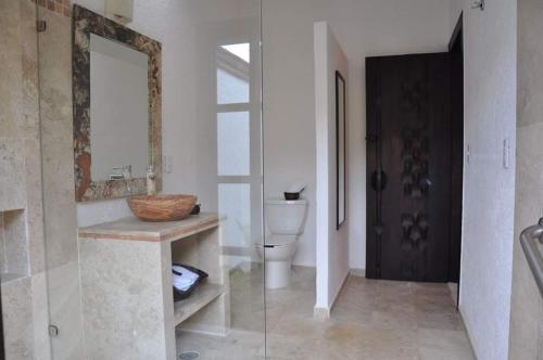 uma casa de banho com um WC, um lavatório e um espelho. em Hotel boutique sana em Cuernavaca