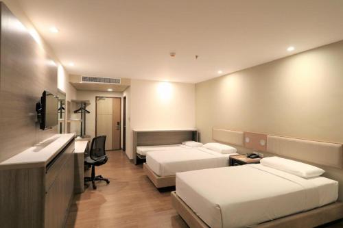 Pokój hotelowy z 2 łóżkami i biurkiem w obiekcie Garden Orchid Hotel & Resort Corp. w mieście Zamboanga