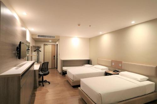 a hotel room with two beds and a desk at Garden Orchid Hotel & Resort Corp. in Zamboanga