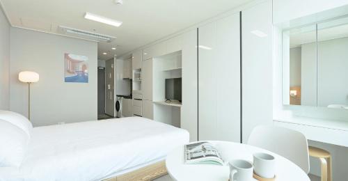 Dahlbit stay في انشيون: غرفة نوم بيضاء مع سرير وطاولة