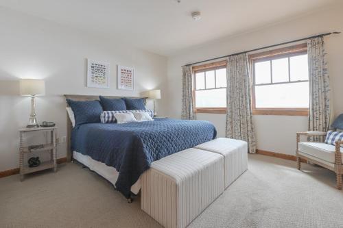 a bedroom with a bed and a chair and a window at The Lodge at Mountaineer Square in Mount Crested Butte