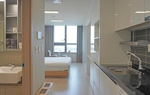 Habitación de hotel con cama y lavabo en Dahlbit stay, en Incheon