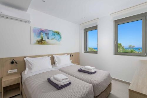 Dos camas en una habitación con dos ventanas. en Villa Panaxia Akte, en Theologos