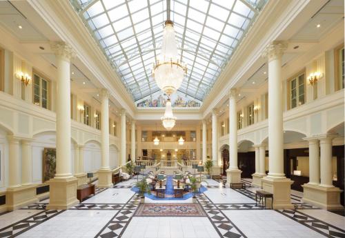 eine große Lobby mit Glasdecke und Säulen in der Unterkunft Huis Ten Bosch Hotel Amsterdam in Sasebo