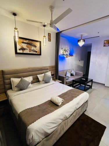 a bedroom with a large bed and a living room at The Luxury Lodge in Noida