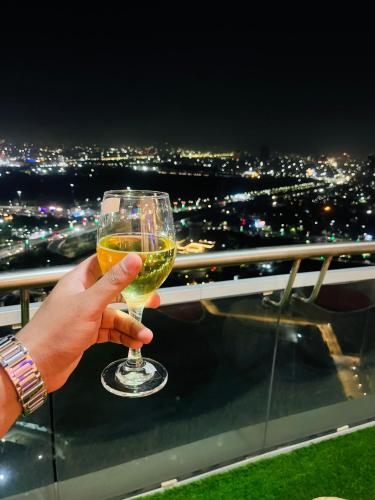 a person holding a glass of wine at night at The Luxury Lodge in Noida