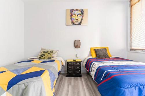 a bedroom with two beds and a painting on the wall at hostal mancora monjitas 755 in Santiago