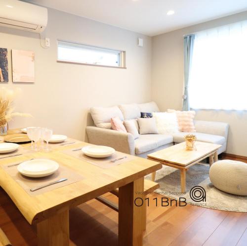 a living room with a table and a couch at YI HOUSE MAX 8people 2BR 1 minute walk from tram station in Sapporo
