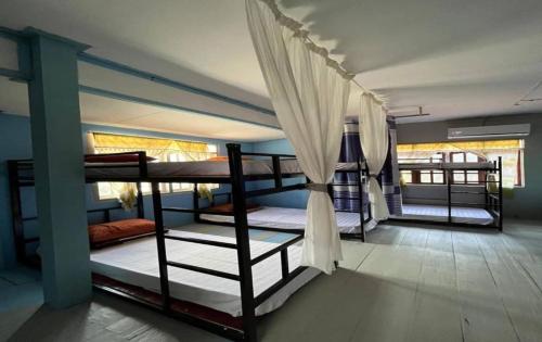 a room with three bunk beds in a room at Queens Backpackers in Vang Vieng