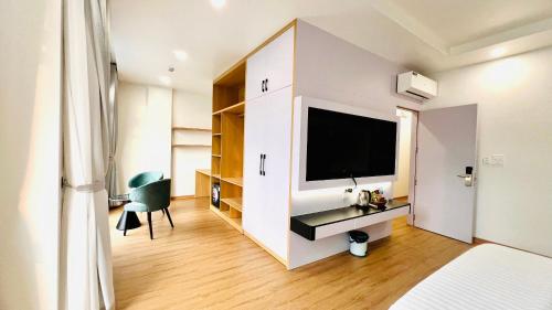 a bedroom with a flat screen tv on a wall at Golden Sea Hotel in Ðông Thôn