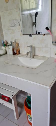 Kaole Cosy Retreat في باجامويو: منضدة الحمام مع الحوض والمرآة