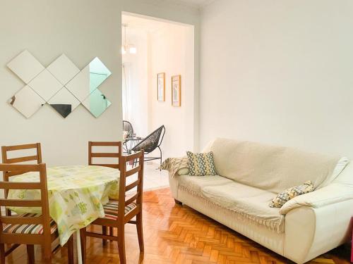 uma sala de estar com um sofá, uma mesa e cadeiras em Apartment Atlantica no Rio de Janeiro