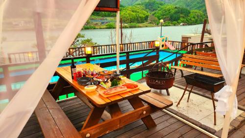 a table with a plate of food on the deck of a boat at Travely Hotel Gapyeong in Gapyeong