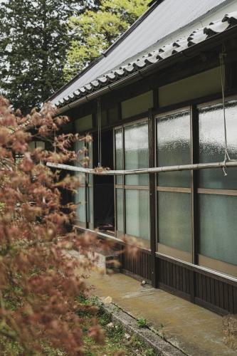 a house with windows on the side of it at 一汁一菜の宿 ちゃぶダイニング Ichiju Issai no Yado Chabu Dining, A Private Farmstay in Rural Kyoto in Ayabe