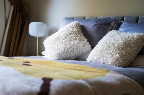 a bed with white pillows and a blue blanket at Yarra Valley Serenity House in Golf Course Resort in Wonga Park