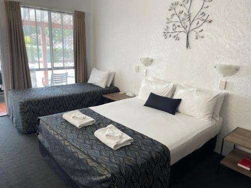 pokój hotelowy z łóżkiem z ręcznikami w obiekcie Bundaberg Spanish Motor Inn w mieście Bundaberg