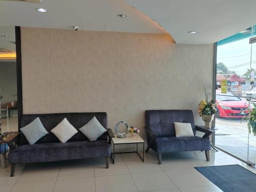 a living room with two chairs and a couch at BG Business Hotel in Bukit Mertajam