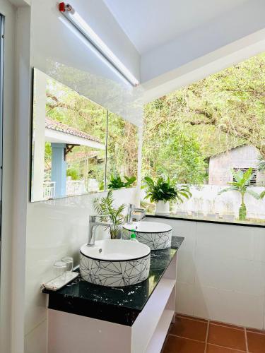 a bathroom with a sink and a large window at SAM VILLA HUE CITY in Thôn Dương Xuân Hạ