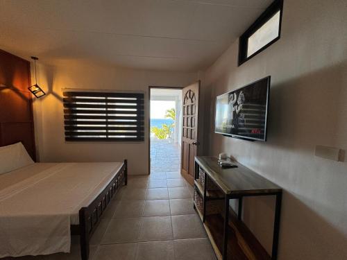 - une chambre avec un lit, une table et une fenêtre dans l'établissement Casa Blanca, à Puerto Galera